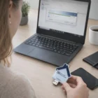 Person holding an Epoxy Dome USBs House Shape by a laptop running backup software.