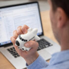 Person squeezes a Stress Balls Shape Plane while checking emails—great promotional stress toy.
