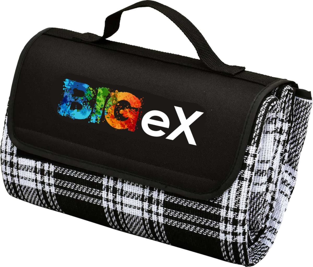 A folded picnic blanket with a plaid pattern featuring black, white, and grey colors. It has a black flap with a handle and the word BigEx in colorful letters printed on it.