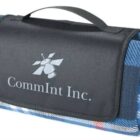 A folded blue plaid blanket with a black flap featuring the CommInt Inc. logo and a carrying handle on top.