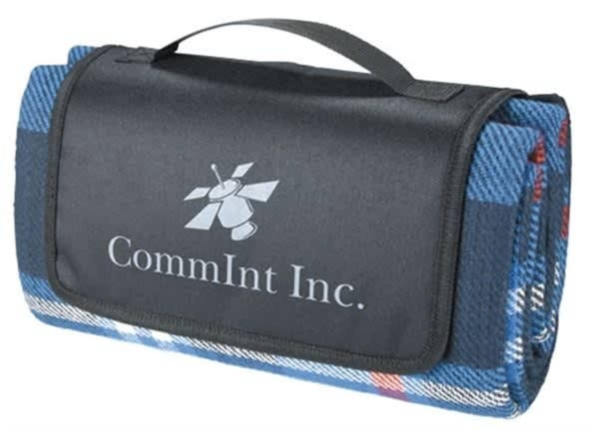 A folded blue plaid blanket with a black flap featuring the CommInt Inc. logo and a carrying handle on top.