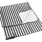 A folded black and white striped blanket with a visible edge and corner turned up, showcasing its design. The stripes run vertically and the edges are neatly hemmed.