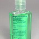 A clear bottle of green hand sanitizer gel with label text detailing ingredients and usage.