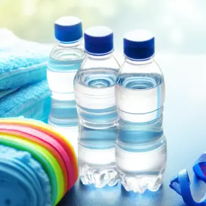 clear_water_bottles_blue_towels_and_colorful_wristbands_on_table_top
