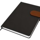Closed black notebook with a brown strap and a ribbon bookmark.