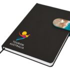Black notebook with Tourism Australia logo and a beach-themed bookmark.