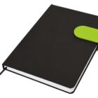 Black notebook with a green clasp and ribbon bookmark, closed and angled on a white background.