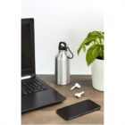 Laptop, water bottle, earbuds, phone, and potted plant on a wooden desk.