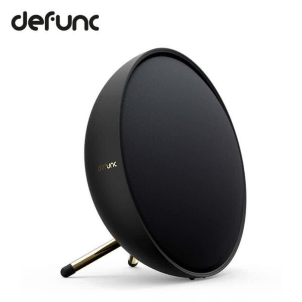 Round black wireless speaker with the Defunc logo, standing on a small angled metal stand.