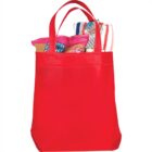 Red tote bag with snacks, towel, and sunglasses inside.