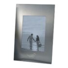 Silver photo frame with a picture of a couple holding hands on the beach.