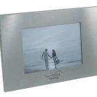 Silver photo frame with black-and-white image of a couple holding hands on a beach.