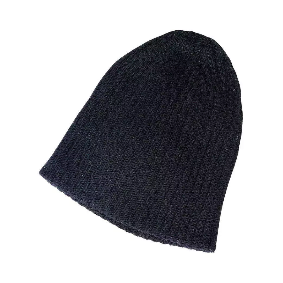 A Cotton drop needle knit beanie in black, shown from the side on a plain white background.
