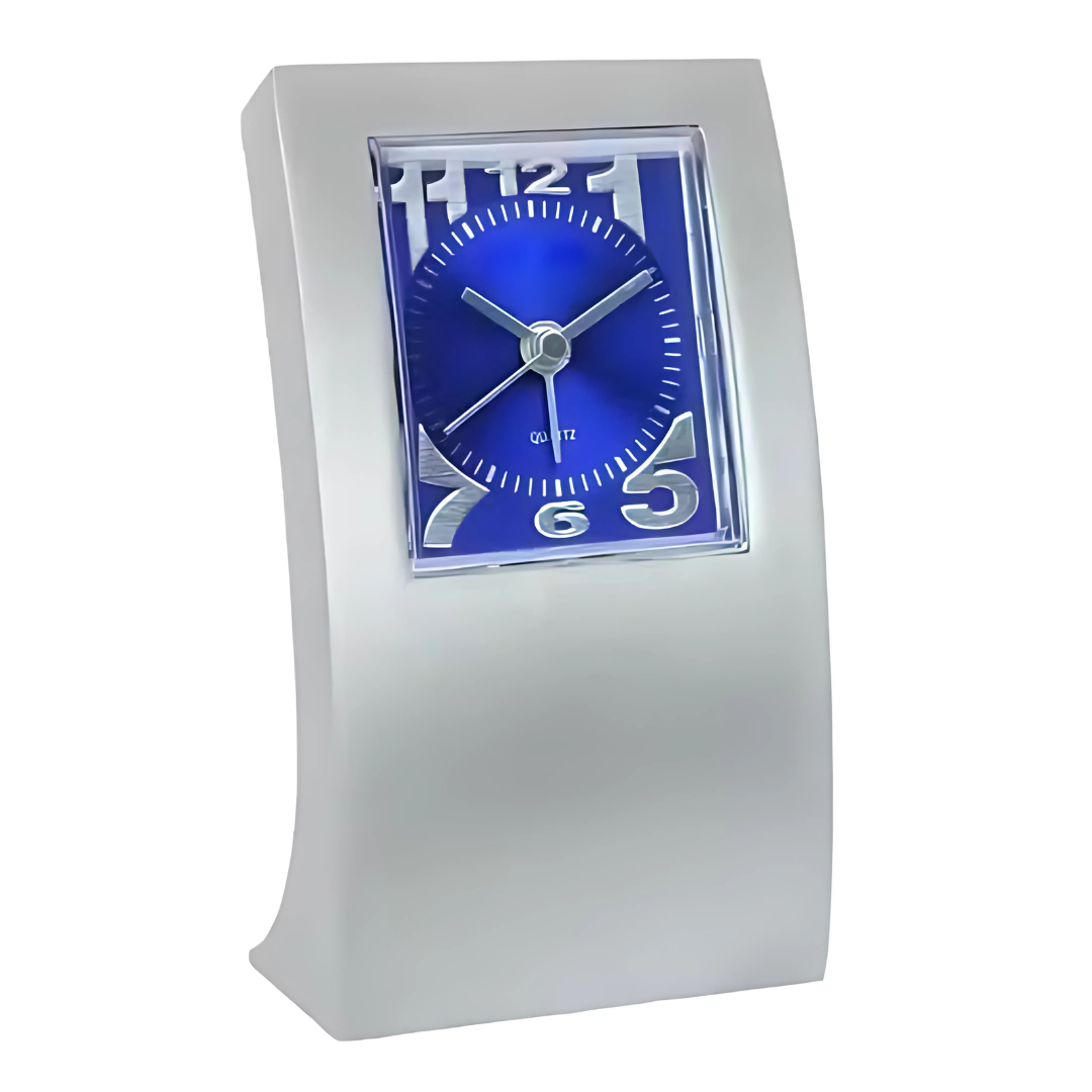 The DIVA DESK CLOCK is a modern silver desk accessory with a rectangular frame and curved design. Its blue face showcases white hour and minute hands, stylized numerals at 2, 4, 8, and 10, plus dots for the remaining hours. A standout piece for any workspace.