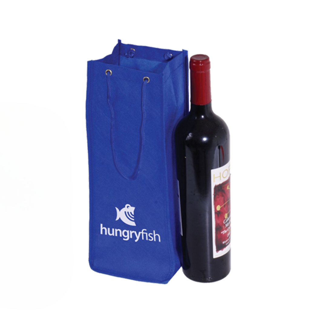 A wine bottle with a dark label is placed beside a blue non-woven Bottle Holder tote, showcasing a white hungryfish logo with a fish. Designed for bottles, it features sturdy handles ideal for carrying wine.