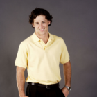 Man smiling in a Premium Corporate Polo Shirt against a gray background.