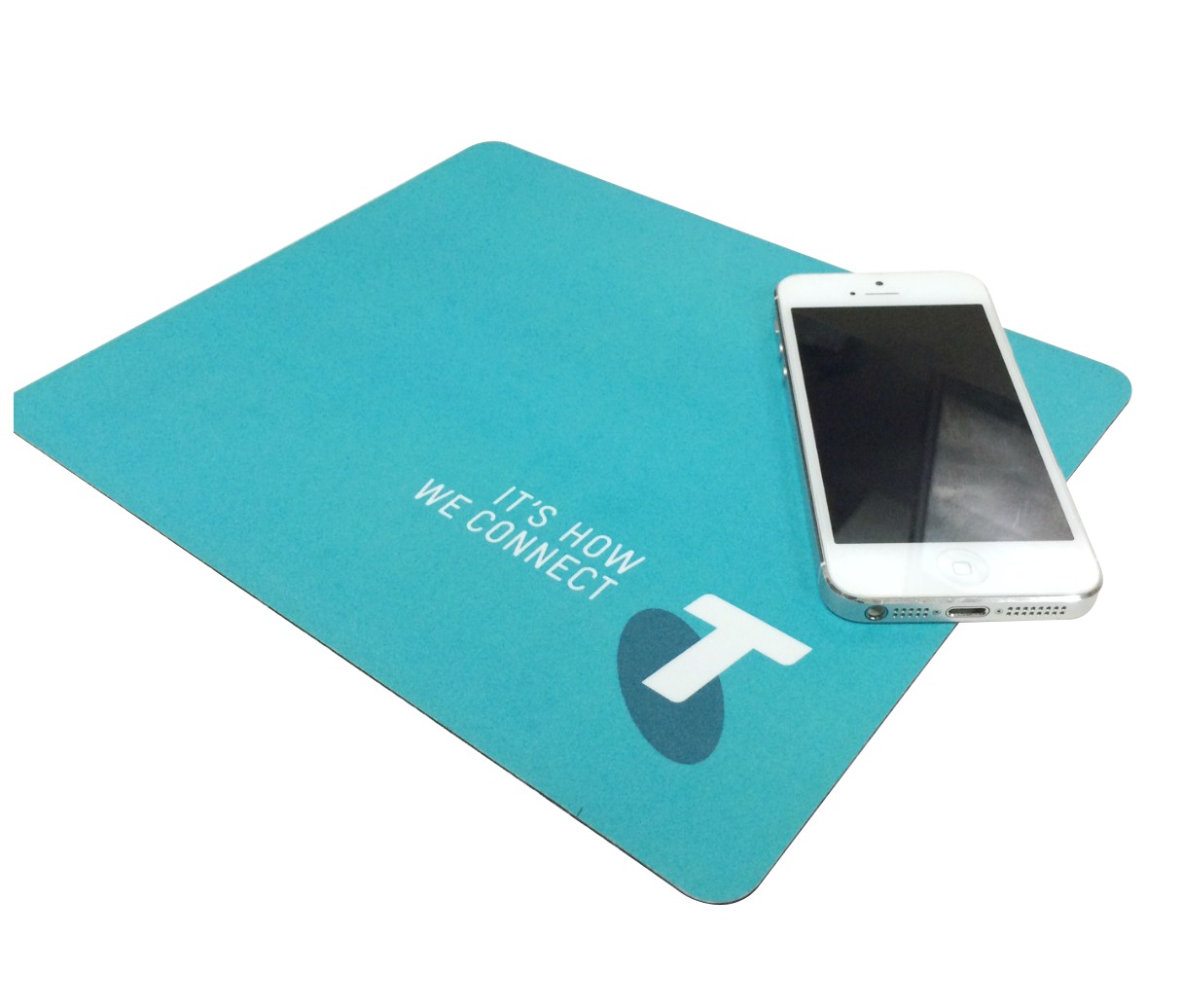 A blue mouse pad with the text Its How We Connect and a stylized T logo. A white smartphone is placed on top of the mouse pad.