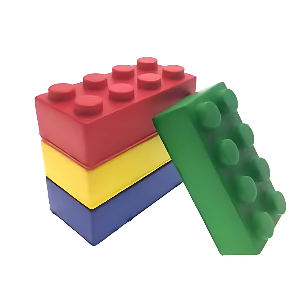 Four Stress Shaped Building Blocks (red, yellow, blue, and green) are stacked atop one another against a white background. The green block leans on the others; all have circular studs on top.