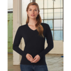 A person with long hair wears a stylish black V Neck Promotional Ladies T Shirts Long Sleeved and blue jeans indoors. Large windows and a light-colored wall in the background create a serene ambiance.