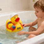 A young child in a bathtub plays with Builder Duckies, each with a hard hat and vest.
