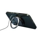 A smartphone with a circular magnetic charger attached to its back is propped up in a horizontal position. The charging cable extends from the charger, and the phones camera lenses are visible.