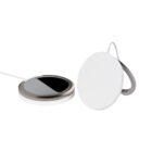 Two circular wireless charging pads are shown. One has a metallic edge and a black surface, while the other is entirely white. Both have attached cables and are positioned upright, with one leaning on the other.