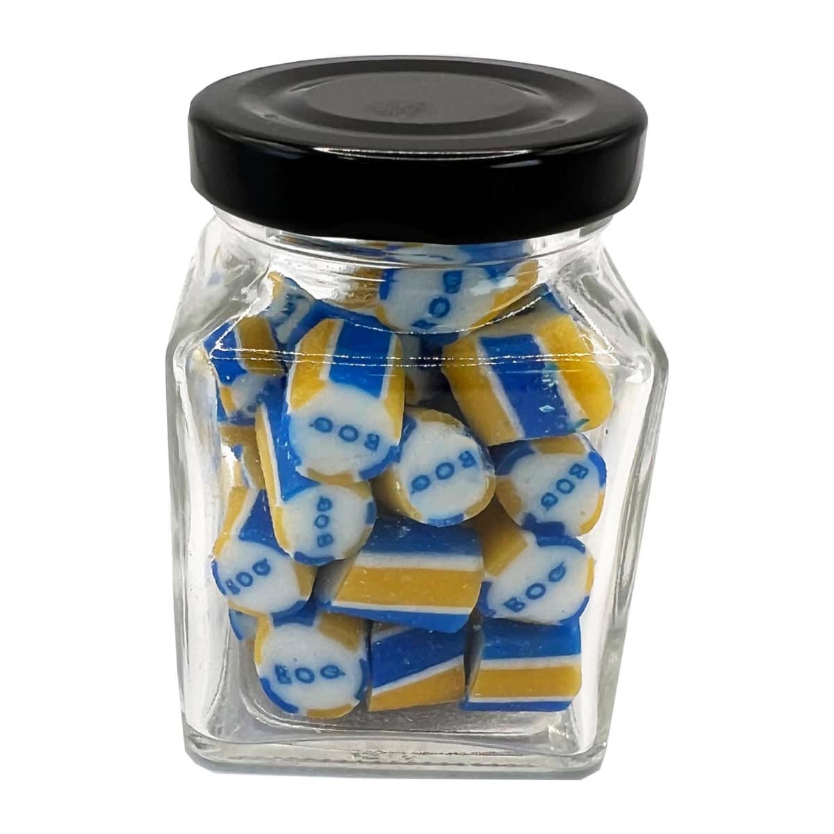 A glass jar filled with blue, yellow, and white candies with BOO on them.