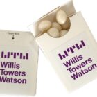 Two white boxes labeled Willis Towers Watson with white candies inside one box.