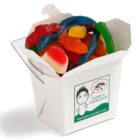 Assorted gummy candies in a white takeout box labeled Food for Thoughts.