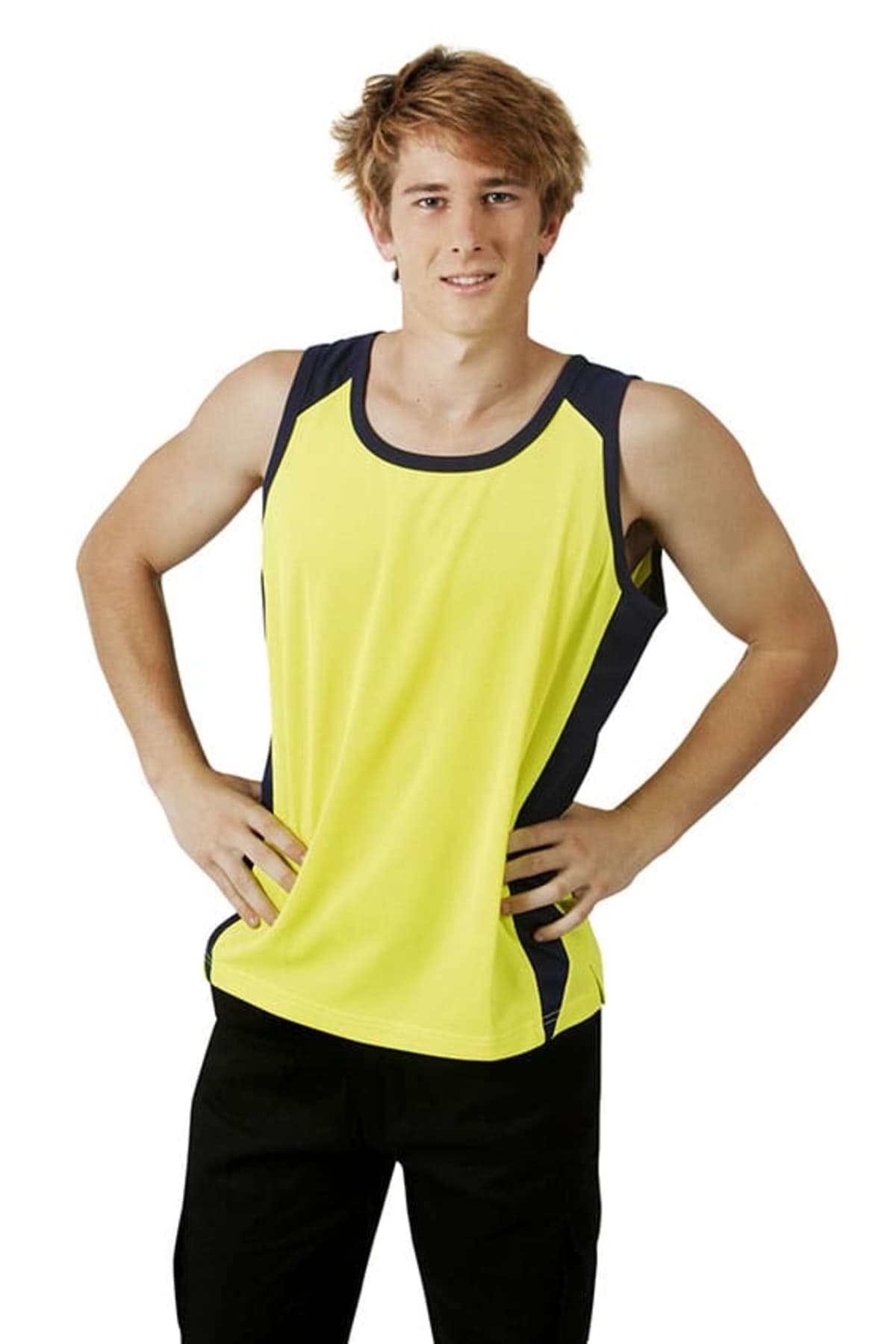 Young man in a yellow athletic tank top and black pants standing with hands on hips.