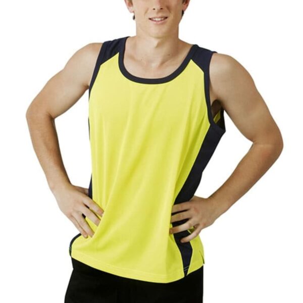 Young man in a yellow athletic tank top and black shorts standing with hands on hips.
