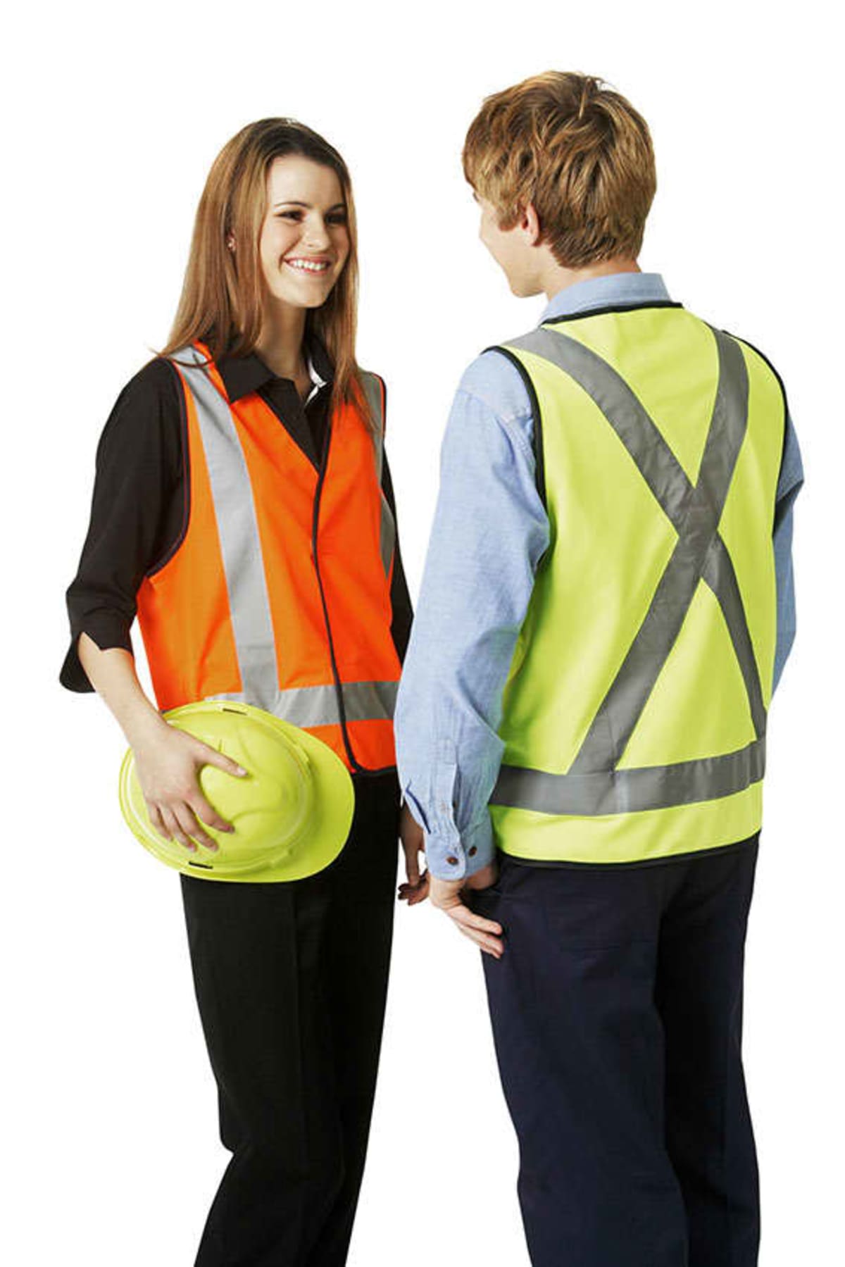 Two people wearing safety vests, one holding a yellow hard hat, standing and talking.
