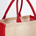Close-up of the Kala Jute coloured bag with red handles and trim on a white background.