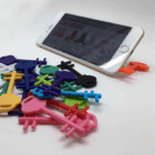 Pembroke Key Phone Stand securely holds your smartphone on any white surface.