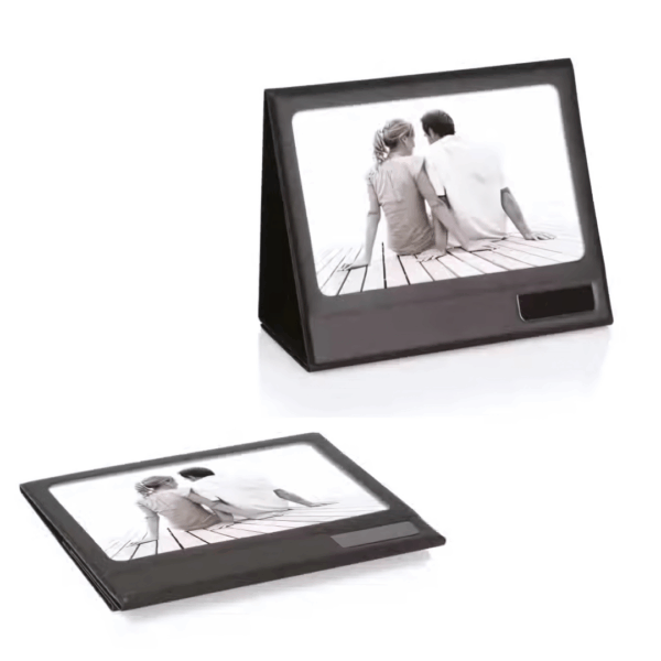 Two people sit on a dock in the Fold up Desk Photo Frame, displayed upright on a desk.