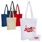 Five tote bags in various colors (blue, black, red, beige, and white) are displayed. The white bag shows a vibrant Coca-Cola logo with a splash effect. A matching white pouch with the same logo is in the foreground.