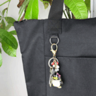 Best Selling Nylon Shopping Tote with keys, penguin keychain, and green plant leaves.