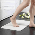 Bare feet on Kyoto Promotional Drying Bath Mats with scattered white flowers for a promo touch.