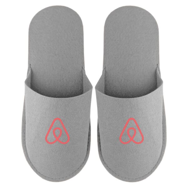 Gray slippers with a red Airbnb logo on each, viewed from above.