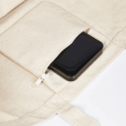 A black smartphone peeks from a beige Super Shopper Bags Logo Decorated zip pocket.