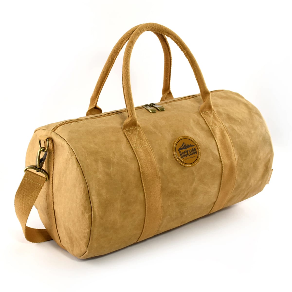 Tan duffel bag with handles, shoulder strap, and round patch logo on the front.