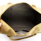Open tan bag with empty gray interior and a zippered pocket on the back wall.