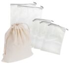 Five mesh produce bags with drawstrings next to a beige cloth drawstring bag.