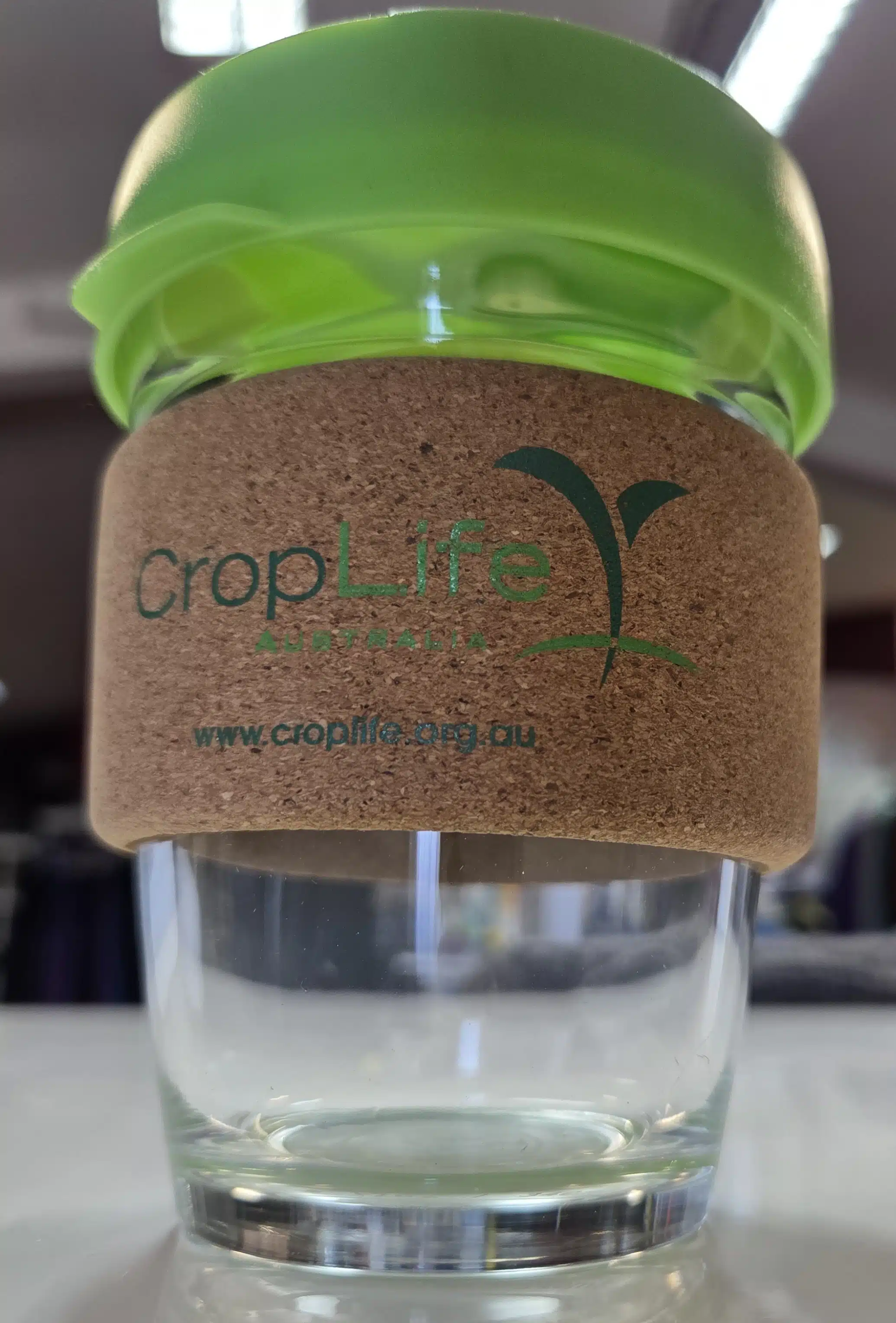 transparent coffee cup with green lid