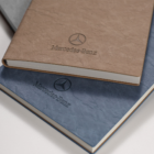 Rustic A5 Mercedes-Benz notebooks in brown, blue, and grey.