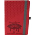 Red notebook with geometric pattern, black dripping lips graphic, and gray elastic band.