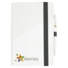 White notebook with a black elastic band, pen, and Childrens Charity logo on the cover.