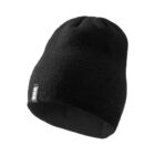 Black knit beanie hat with a small rectangular tag on the side, isolated on white background.
