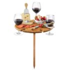 Portable wooden table with wine, cheese, strawberries, and charcuterie.