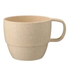 Beige speckled mug with a handle on a white background.